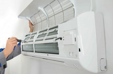 Technician repairing an air conditioner in a Dubai home
