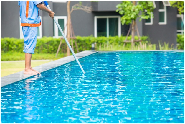 Technician cleaning a residential swimming pool in Dubai